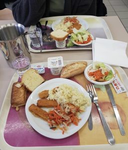 Mittagessen in der Schulmensa - Reis, Fischstäbchen, Salat