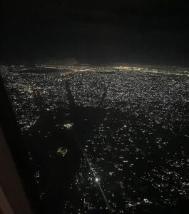 Blick aus dem Flugzeug auf die beleuchtete Stadt