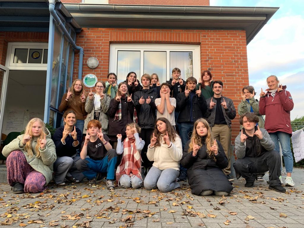 Teilnehmerinnen und Teilnehmer der SV-Fahrt. Alle halten zwei Finger in die Luft, was so viel bedeutet wie: Ich stimme dem zu.