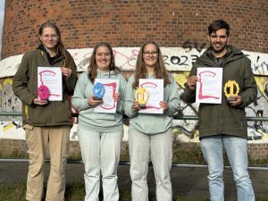 Stolze Gewinner mir ihren Urkunden auf den Abitreppen
