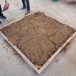 Die Arbeitsfläche wird mit Sand eingeebnet