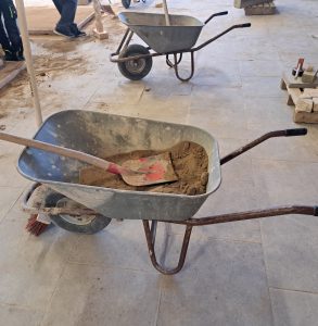 Schubkarre mit Sand und Schaufel