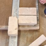 Die Kalk-Sandsteine müssen alle die gleiche Fugenbreite haben. Der Zollstock hilft dabei.