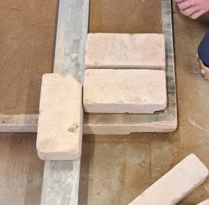 Die Kalk-Sandsteine müssen alle die gleiche Fugenbreite haben. Der Zollstock hilft dabei.