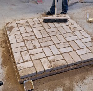 Nun werden die Fugen mit Sand gefüllt.