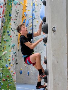 Junge klettert die Wand hinauf